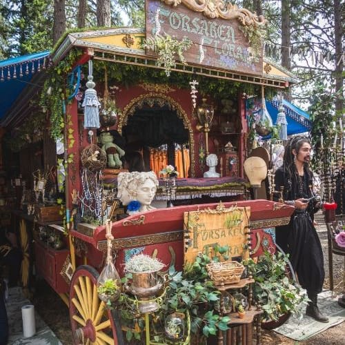 A merchant selling wares out of an elaborate wheeled cart